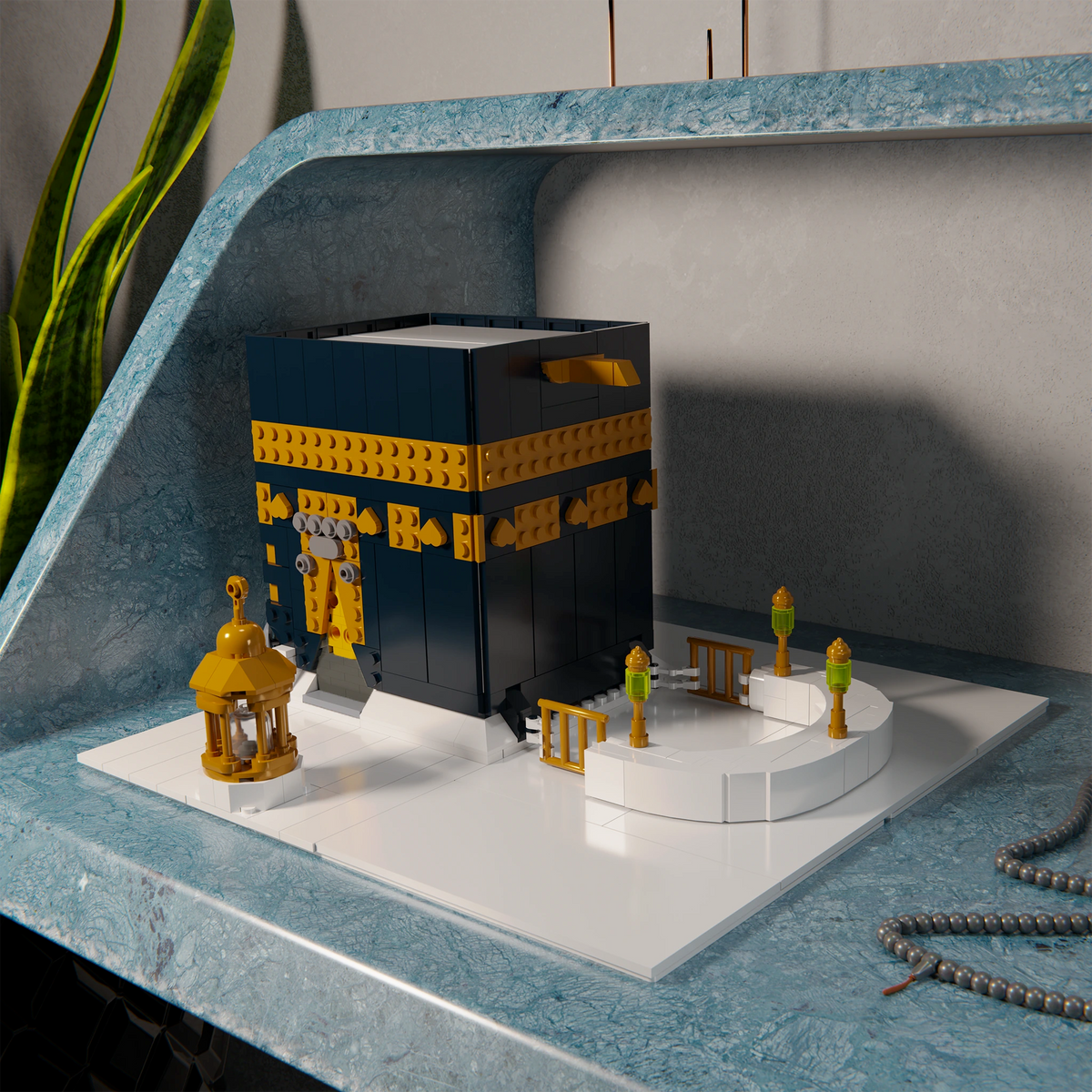 Kaaba Bauset aufgebaut auf einem Schreibtisch mit Gebetskette und Pflanze